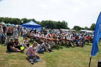 Viele Menschen sitzen auf dem Rasen